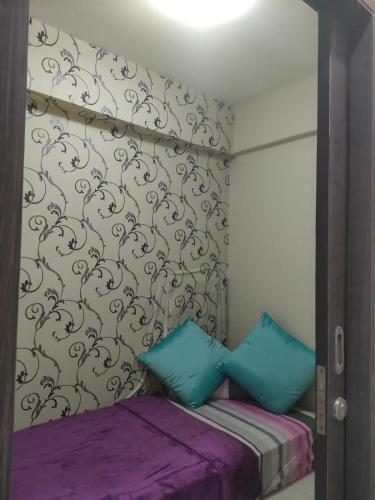 uma cama com duas almofadas azuis num quarto em The jarddin apartment 2BR by kanaya em Bandung