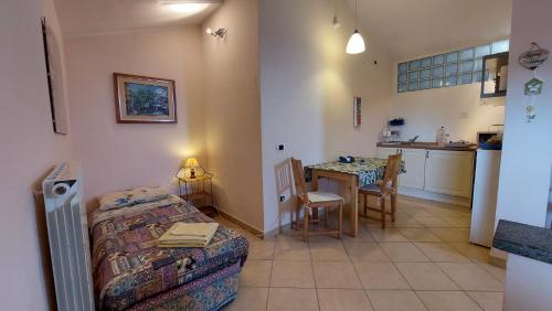 a room with a bed and a table and a kitchen at A Viterbo Terme "Casa Vacanze Al Melograno" in Viterbo
