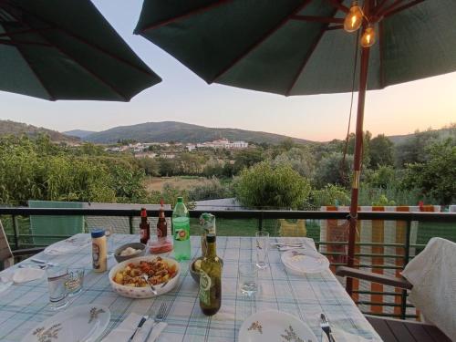 a table with a bowl of food and bottles of wine at Cantinho da Saudade in Góis