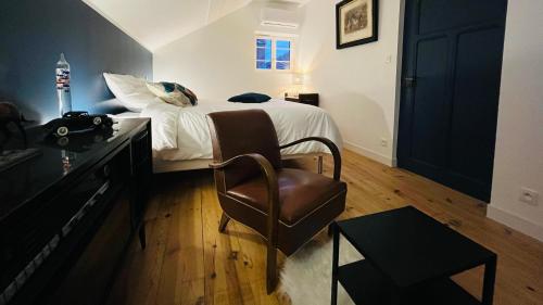 - une chambre avec un lit et une chaise dans l'établissement Villa Les Roches d'Yzeron, à Yzeron