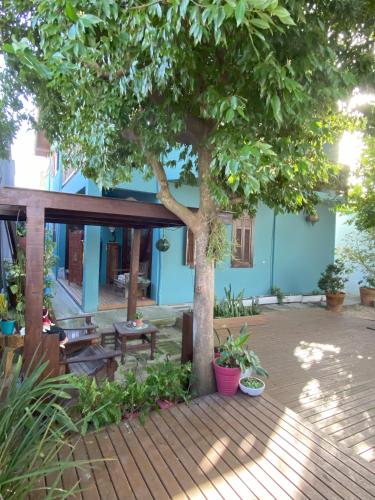 a tree in front of a building with a wooden deck at Solar das Pétalas Guest House in Florianópolis