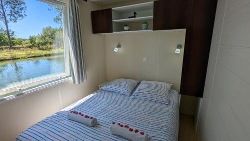 małe łóżko w małym pokoju z oknem w obiekcie Cottage flottant terrasse gamme supérieure option jacuzzi proche Dijon 