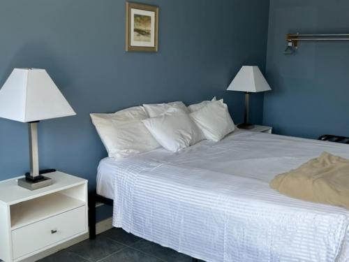 a blue bedroom with a white bed and two lamps at Seagrass Inn in Old Orchard Beach