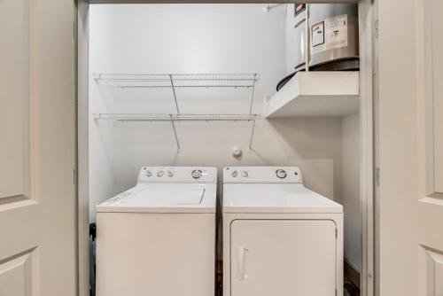 a small kitchen with two white appliances in a room at Trendy 2BR I Pool I Gym I Free Parking I Workspace in Dallas