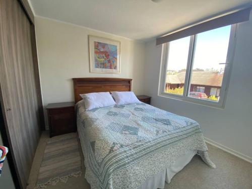 1 dormitorio con cama y ventana en Acogedor dpto en puerto varas, en Puerto Varas