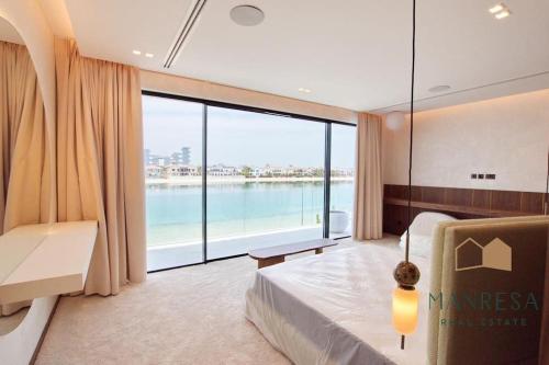 ein Schlafzimmer mit einem Bett und einem großen Fenster in der Unterkunft ULTRA Modern Villa Manresa with Private Beach & Infinity Pool on Palm Island in Dubai