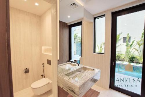 ein Badezimmer mit einer großen Badewanne und einem WC in der Unterkunft ULTRA Modern Villa Manresa with Private Beach & Infinity Pool on Palm Island in Dubai