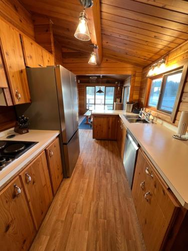 a kitchen with wooden cabinets and stainless steel appliances at April Point Harbour House in Quathiaski Cove