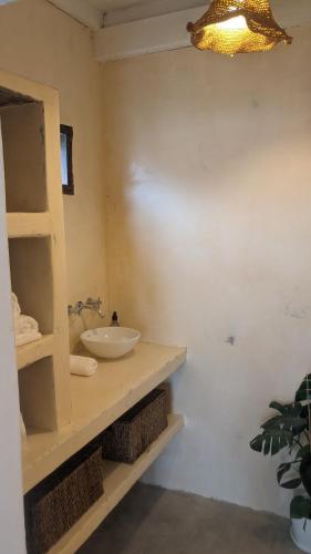 a bathroom with a sink and a counter with a mirror at Casa Raices in Quequén