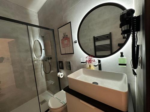 a bathroom with a sink and a mirror and a toilet at Villa Mala Praha Experience in the Center of Žilina in Žilina