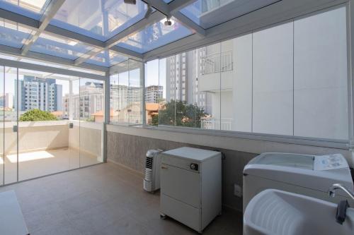 a bathroom with a toilet and a large window at Cobertura 2 quartos Tucuruvi in Sao Paulo
