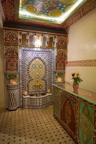 a room with a large room with a tile wall at Flowers riad in Marrakech