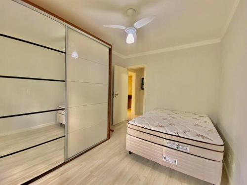 um quarto com uma cama e um armário de vidro em Apartamento com fácil acesso ao Vale dos Vinhedos em Bento Gonçalves