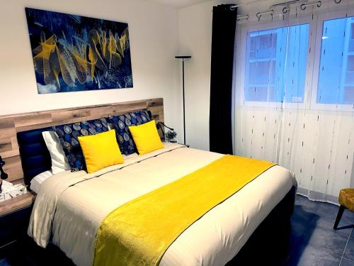 1 dormitorio con 1 cama grande con almohadas amarillas en Cosy flat Marseille Joliette, secured parking lot, en Marsella