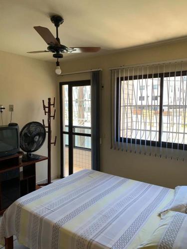 1 dormitorio con 1 cama y ventilador de techo en APTO PRAIA DO MORRO, 02 QUARTOS C SUITE, WI-FI, GARAGEM, 1 ANDAR ESCADA. en Guarapari