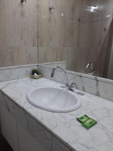 a bathroom counter with a sink and a mirror at Apartamento 2010 in Goiânia