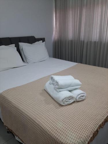 a bed with two towels sitting on top of it at Apartamento 2010 in Goiânia