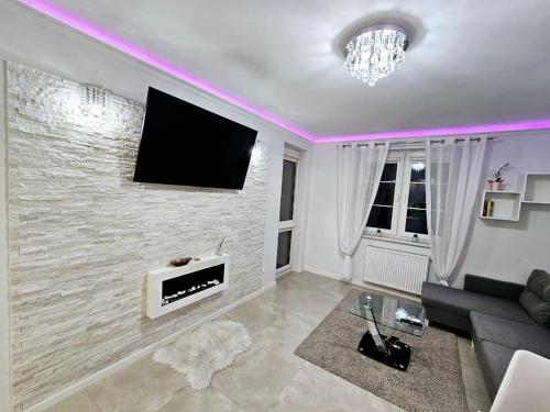 sala de estar con TV de pantalla plana en la pared en Apartament Chill & Lux, en Ostróda