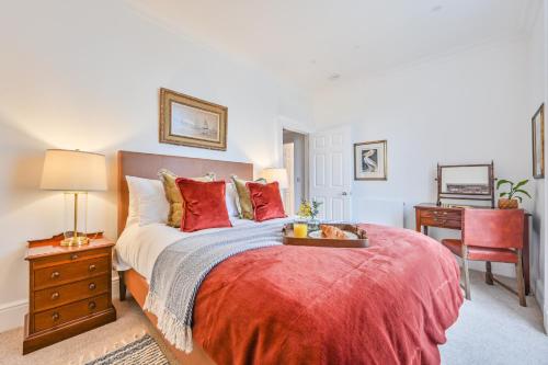 a bedroom with a large bed with red pillows at 9 Admiralty House Stunning Luxury Apartment with free parking in Plymouth