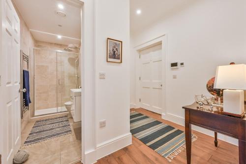 a bathroom with a shower and a desk and a toilet at 9 Admiralty House Stunning Luxury Apartment with free parking in Plymouth