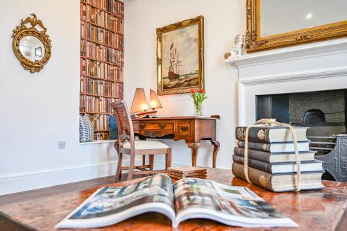 a living room with a desk and a book on a table at 9 Admiralty House Stunning Luxury Apartment with free parking in Plymouth