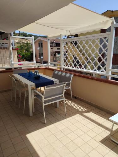 a patio with a table and chairs on a balcony at Moby Dick House in Villasimius