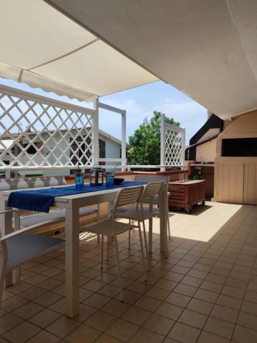 a patio with a table and chairs on a roof at Moby Dick House in Villasimius