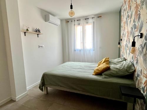 Dormitorio pequeño con cama y ventana en Chaleureuse maison avec terrasse et garage, en Espira-de-lʼAgly