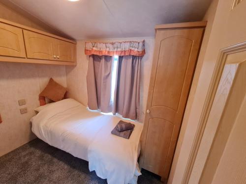 ein kleines Schlafzimmer mit einem Bett und einem Fenster in der Unterkunft Willerby Holiday Home in Durham