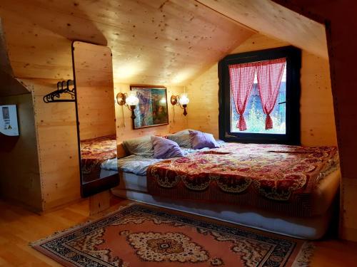 1 dormitorio con 1 cama en una cabaña de madera en Tri breze en Hum Breznički