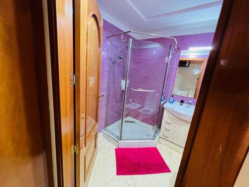 Chez Alex في مراكش: حمام مع دش وسجادة حمراء