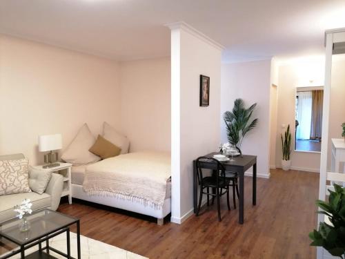 ein Wohnzimmer mit einem Bett und einem Tisch in der Unterkunft Apartment SiLa in Kassel