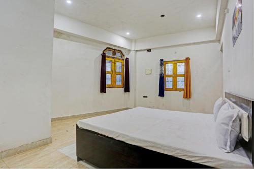 una camera con un letto e due finestre di OYO S.R Group Of Hotel a Kānpur