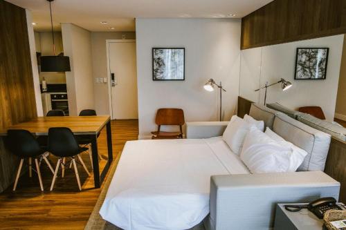 a living room with a bed and a table at Apartamento completo no Brava Hotel in Florianópolis