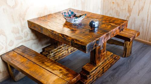 パンギプジにあるHostal Central Panguipulliのベンチの隣にあるバスケットが置かれた木製のテーブル