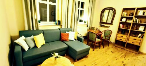 sala de estar con sofá verde y mesa en Drzewna Apartamenty - Kupiecka 39 en Zielona Góra