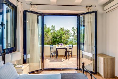 Schlafzimmer mit Blick auf einen Tisch und Stühle in der Unterkunft Villa Salanti in Koilás