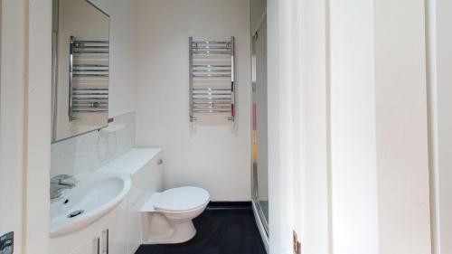 a white bathroom with a toilet and a sink at Quieter Studios Centre of Nottingham in Nottingham