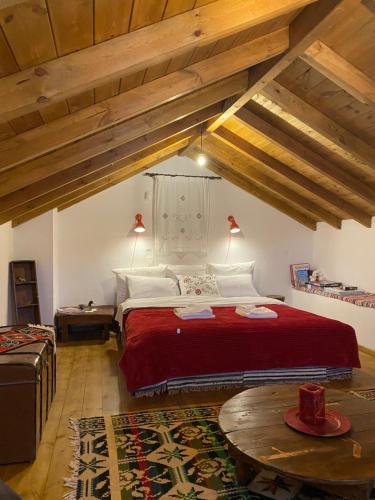 a bedroom with a large bed with a red blanket at Ypsus House Stemnitsa in Stemnitsa