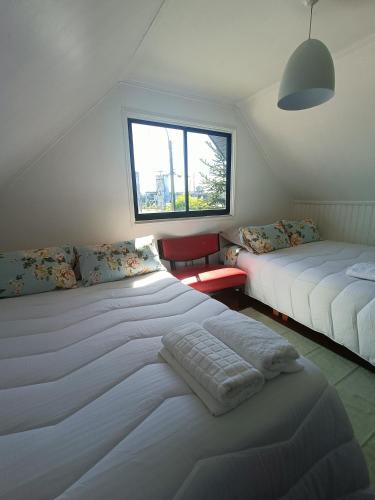 a bedroom with two beds and a window at Casa Huésped Los Pablos in Temuco