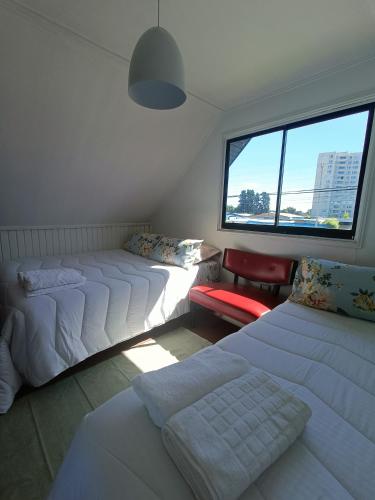 a bedroom with three beds and a window at Casa Huésped Los Pablos in Temuco