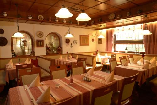 une salle à manger avec des tables, des chaises et des lumières dans l'établissement Landgasthof Friedrich, à Trebgast