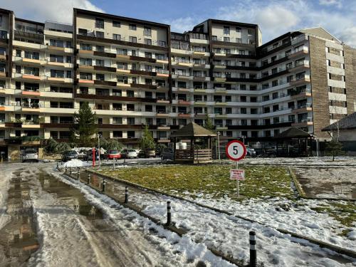 a large apartment building with snow in front of it at HCT Sinaia Apartment in Sinaia