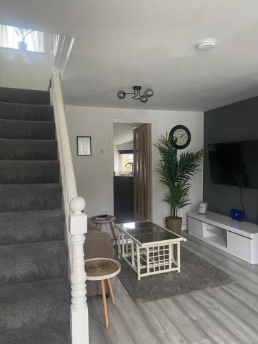 a living room with a staircase with a tv and a table at “1-Bed Haven in Snowdonia nr ZipWorld, Snowdon” in Blaenau-Ffestiniog