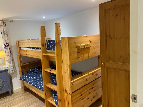 1 dormitorio con 2 literas y puerta en Orchard Cottage, Pwllheli, North Wales, en Pwllheli