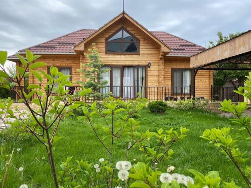 uma casa com um quintal com relva verde em Сруб на Иссык Куле em Chon-Sary-Oy
