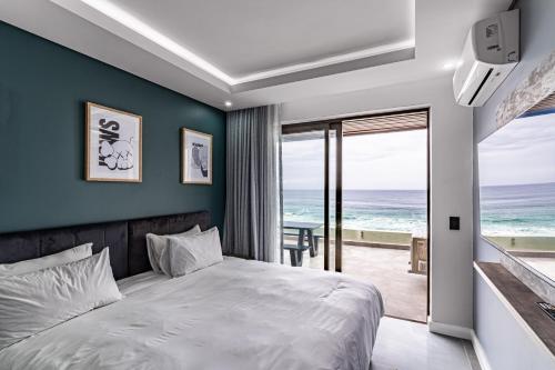 a bedroom with a bed and a view of the ocean at Modern Chic Beachfront Apartment in Ballito