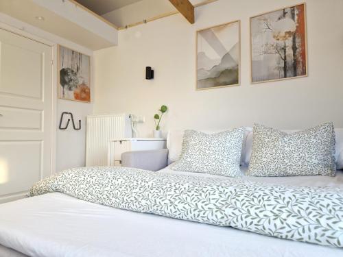a bedroom with a large white bed with pillows at La Petite bohéme with free parking in Stockholm