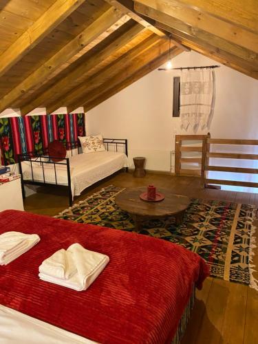 Sala de estar con 2 camas y mesa en Ypsus House Stemnitsa, en Stemnitsa