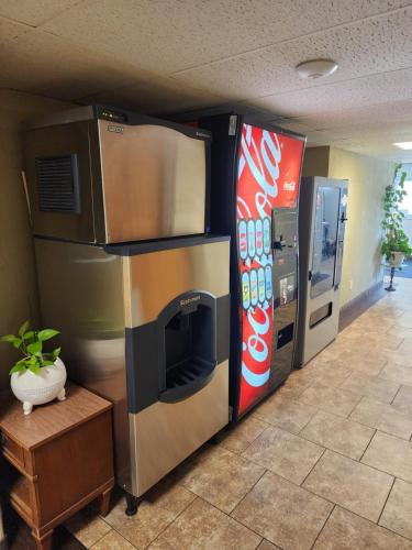 um frigorífico e uma máquina de coca-cola num quarto em Lantern Motel em Milbank